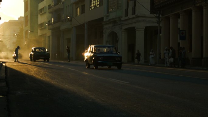 哈瓦那夕阳下的行人和名车