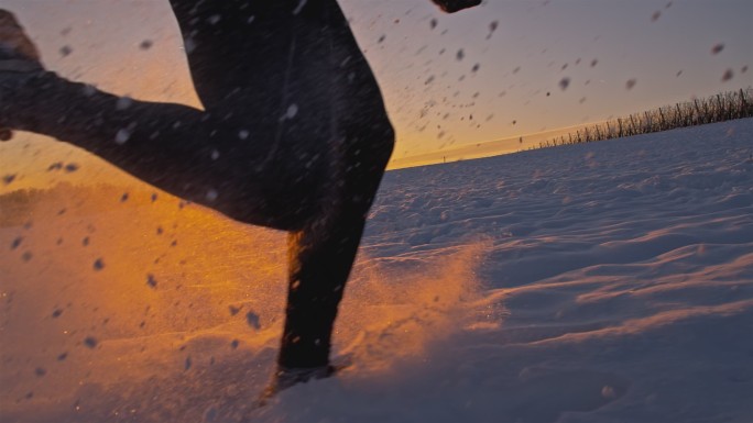 落日时分在雪地里奔跑的慢跑者