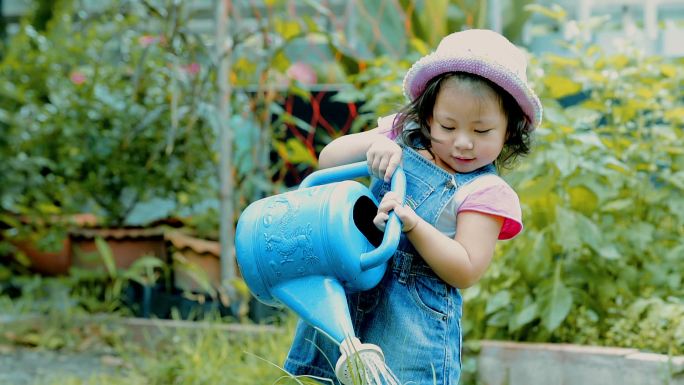 小女孩在花园里给植物浇水，念：呵护自然