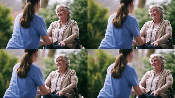 一位老妇人和她的看护人在户外聊天