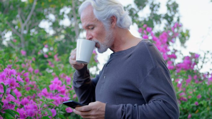 老年人边喝咖啡边用手机