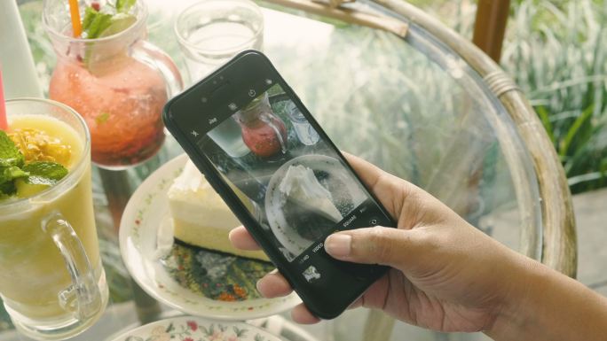 女性用智能手机拍摄食物