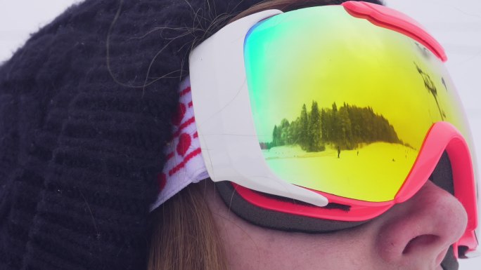 通过眼镜反射看到一个滑雪运动员在滑雪