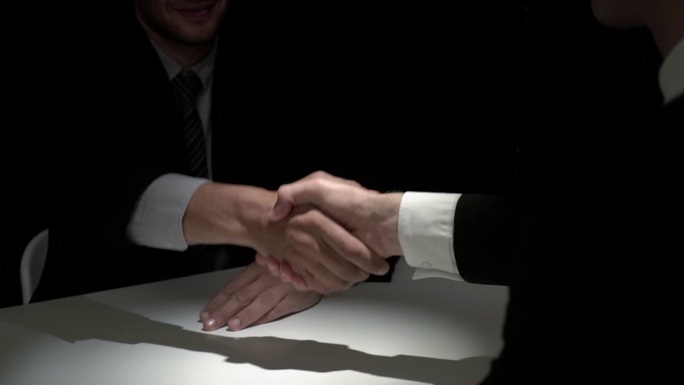 商业伙伴在黑暗中握手