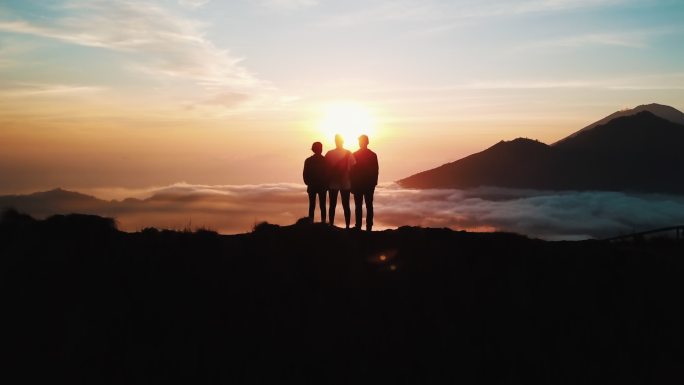 一群朋友站在山上观看日出