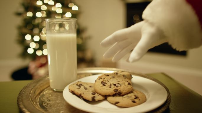 圣诞老人从托盘里拿起一块巧克力饼干