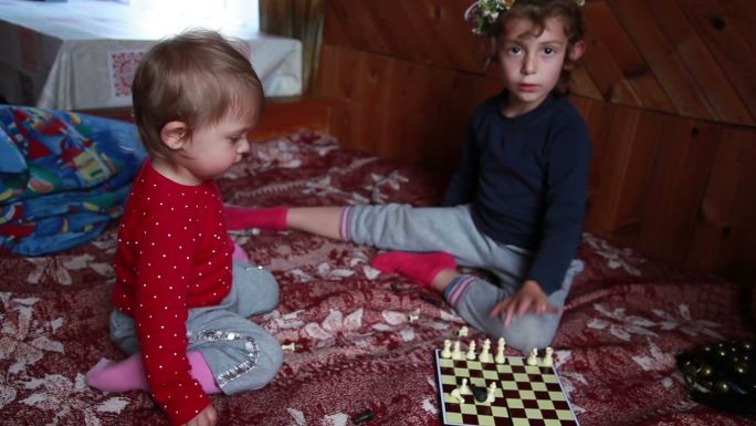 两个小妹妹在床上玩棋子