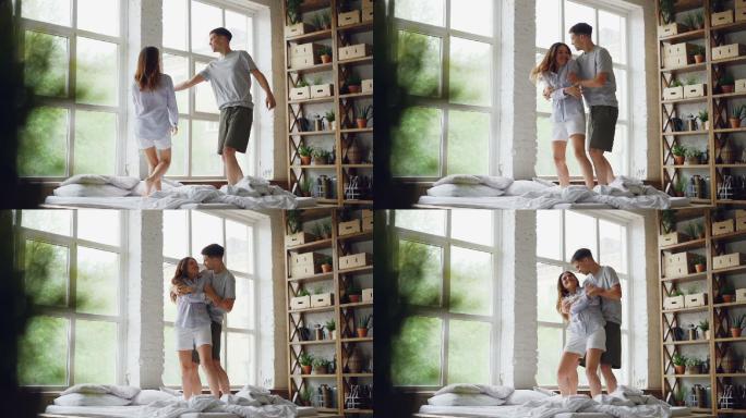 一对情侣在床上跳舞，拥抱在一起的慢镜头。