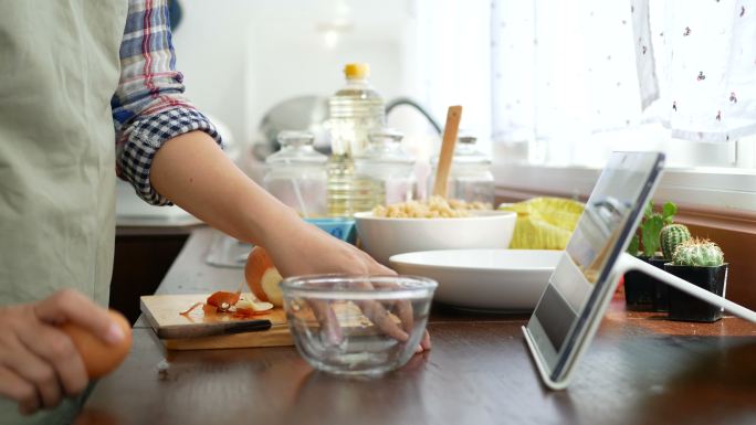 女性通过平板电脑在网站上播放烹饪在线视频