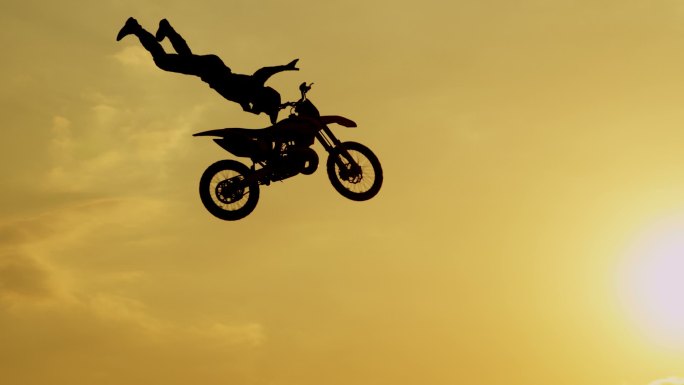 极限职业摩托车手在阳光下跳跃自由式