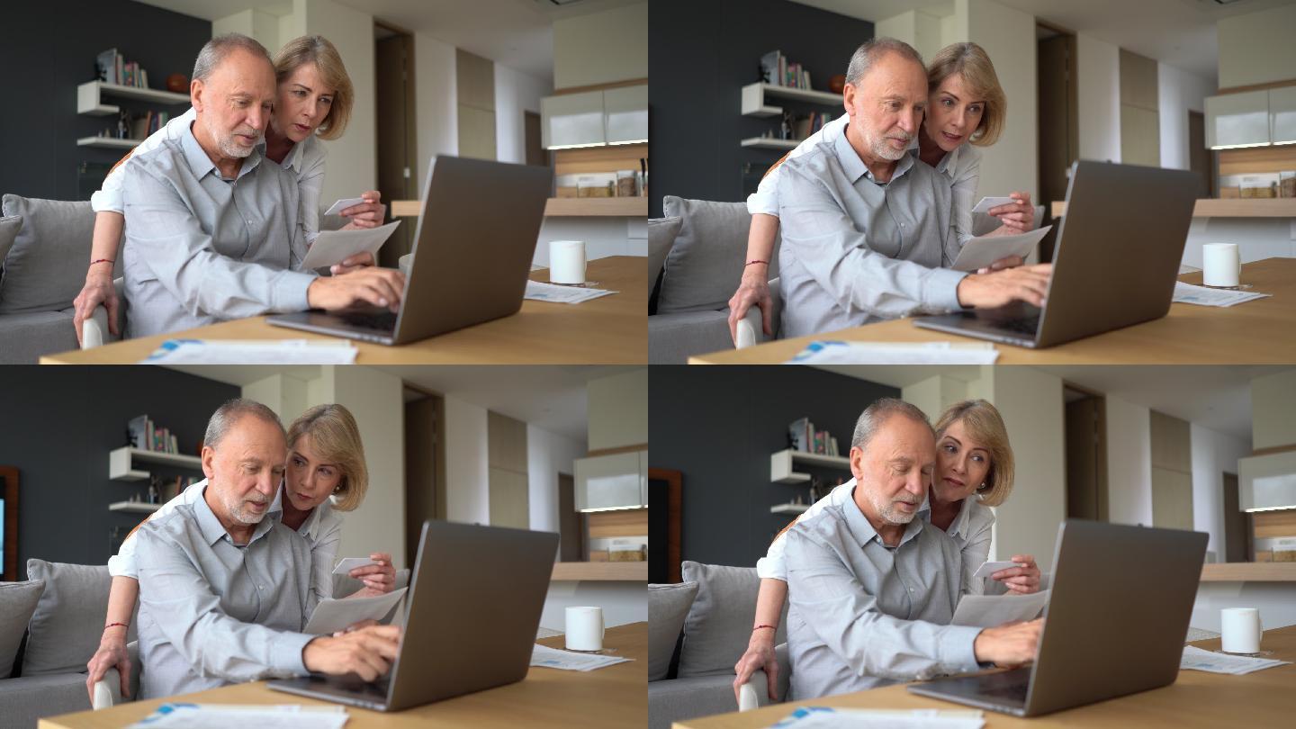 老夫妇在家用笔记本电脑电子支付