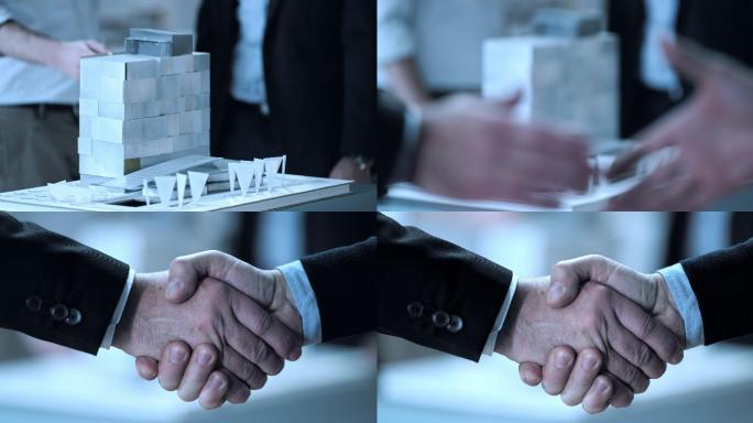 两个男人在建筑模型前握手