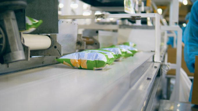 工人把传送带上的薯片装进盒子里