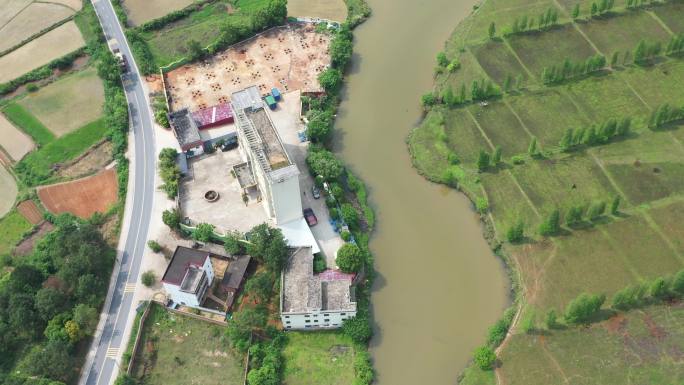 俯拍一条小溪流经过农田和村庄