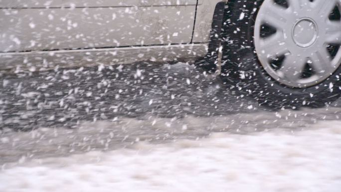 汽车车轮在雪地里行驶的慢镜头