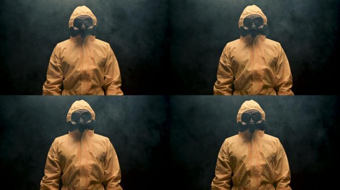 身穿防护服和防毒面具的人站在雾中