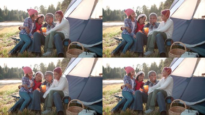 祖父母和孙子孙女在湖边的帐篷外放松