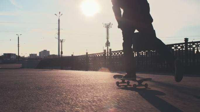 在城市街道上滑滑板的男人