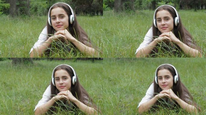 草地上的女孩听音乐。