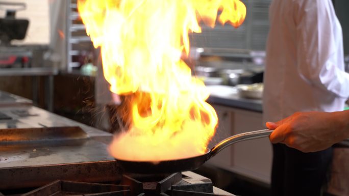 厨师用平底锅烹调火焰的特写镜头
