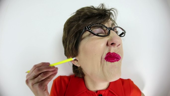 一个女人用铅笔擦耳朵