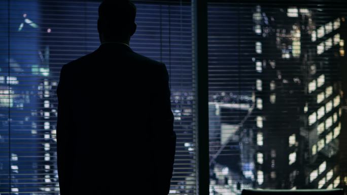 深夜，商人站在办公室的窗口看景色