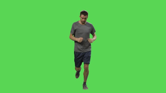 一个男子在绿幕面前慢跑。