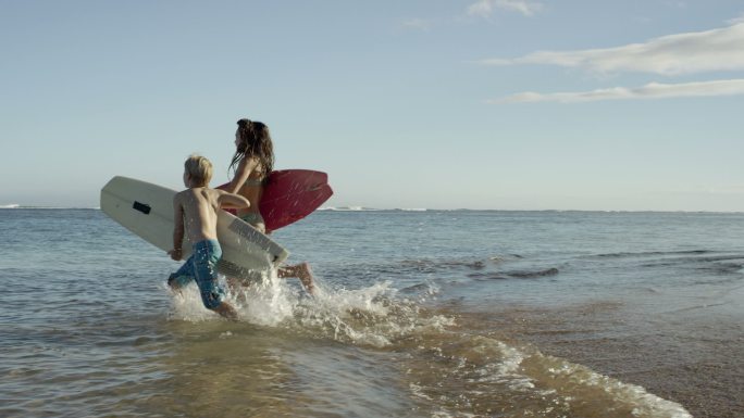 一家人在夏威夷的热带海滩度假冲浪。