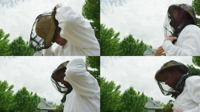 一个养蜂人戴上养蜂帽和面纱