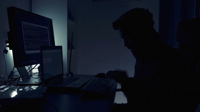 黑客在黑暗中用电脑打字