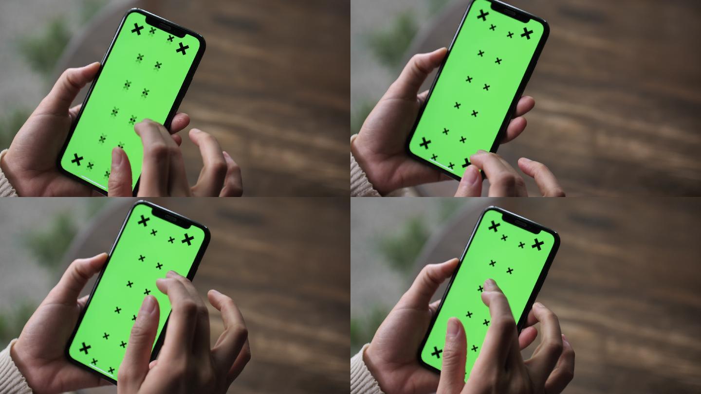 女士手持智能手机，屏幕显示绿色，特写