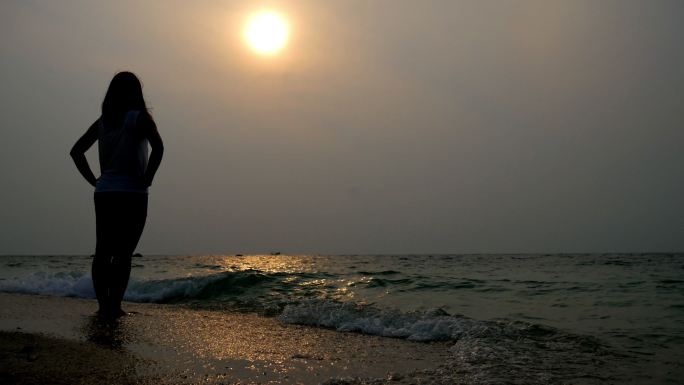 落日时分海滩上的孤独女人