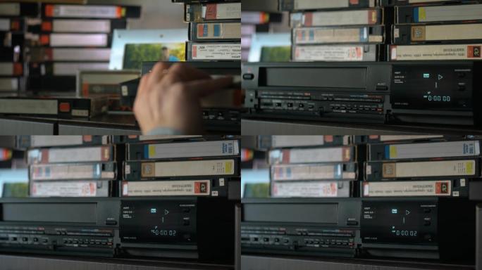 手拿着一盒录像带，把它插入录像机并推动播