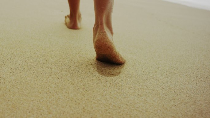 女子光脚走在海滩上脚步特写