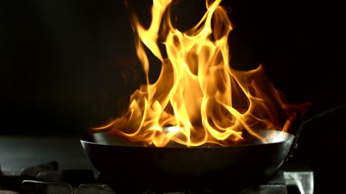 从锅里喷出的火焰在炉子上燃烧食物