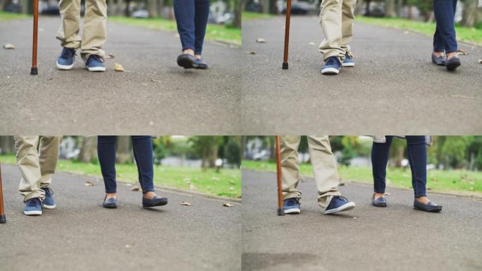 杵拐杖老人和妻子在公园里散步