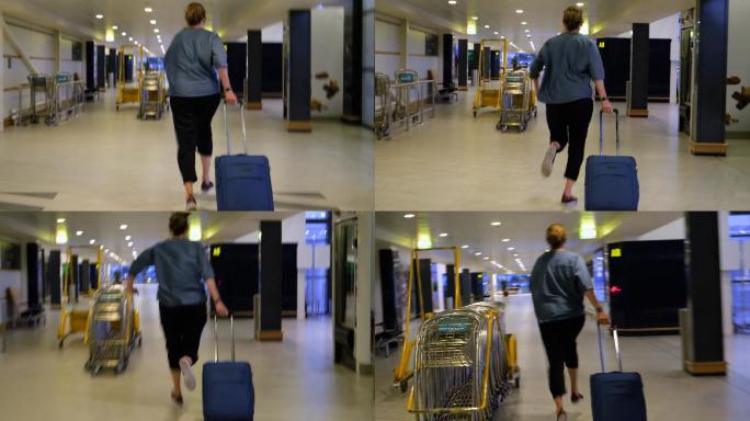 赶路的女人拿着手提箱在机场跑