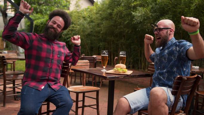 两个男性朋友在啤酒馆喝啤酒吃东西