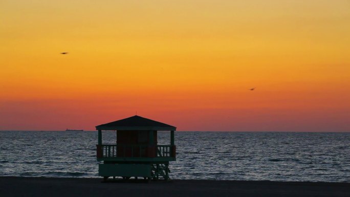 日落时海边的救生员小屋