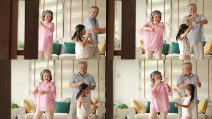 快乐的老年夫妇和孙女在家里跳舞。