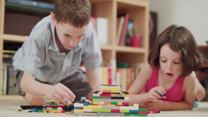 两个孩子在家玩塑料砖