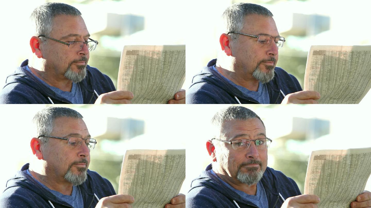 戴眼镜的成熟男人看报纸