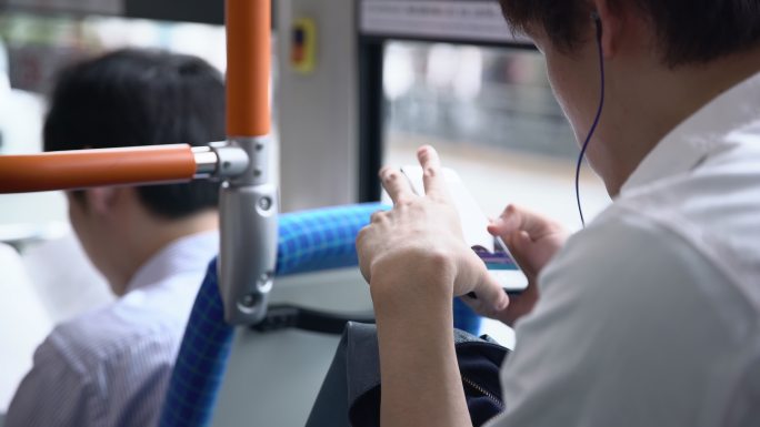 通勤者在公交车上使用智能手机