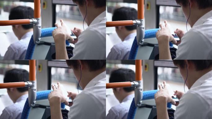 通勤者在公交车上使用智能手机