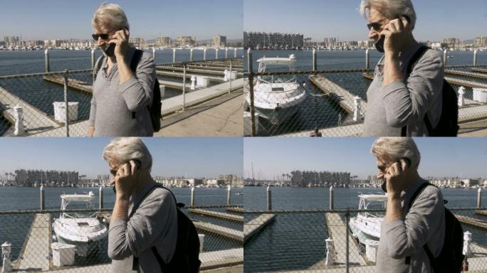 男人在码头用翻盖电话聊天