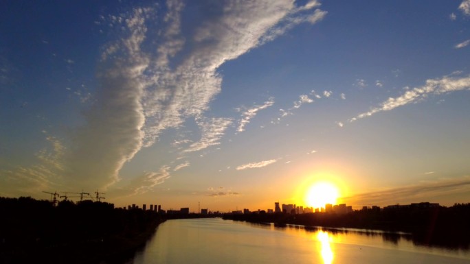 大河落日城市剪影日落城市城市晚霞