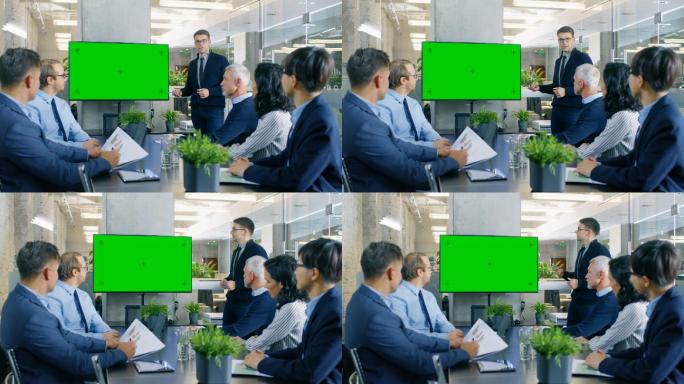 指着绿色的电视屏幕向他的商业同事做报告。