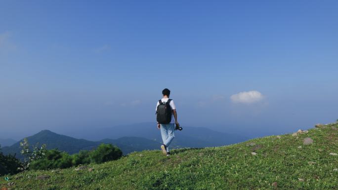 4K一个年轻男性登顶山峰拍照