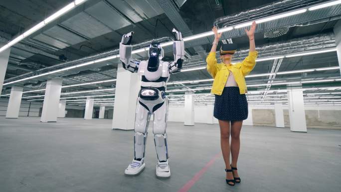 戴着虚拟现实眼镜的女人控制机器人移动手臂