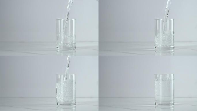 慢动作：把水倒进白底的杯子里。
